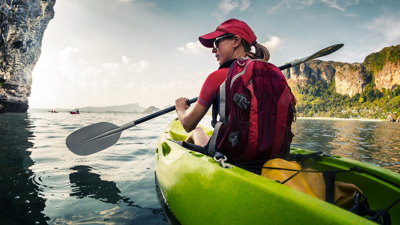 A woman is kayaking; image used for HSBC Singapore Travel Insurance.