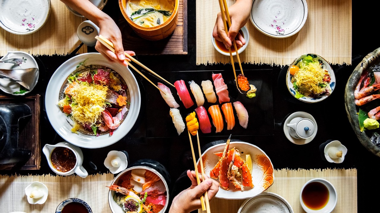 A group is sharing a meal; image used for HSBC Singapre Credit Card Promotions.