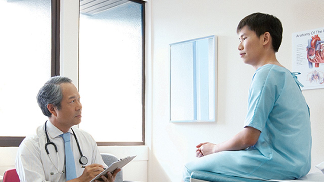 一位男士与医生谈话；图片使用于汇丰新加坡早期重大疾病保险。