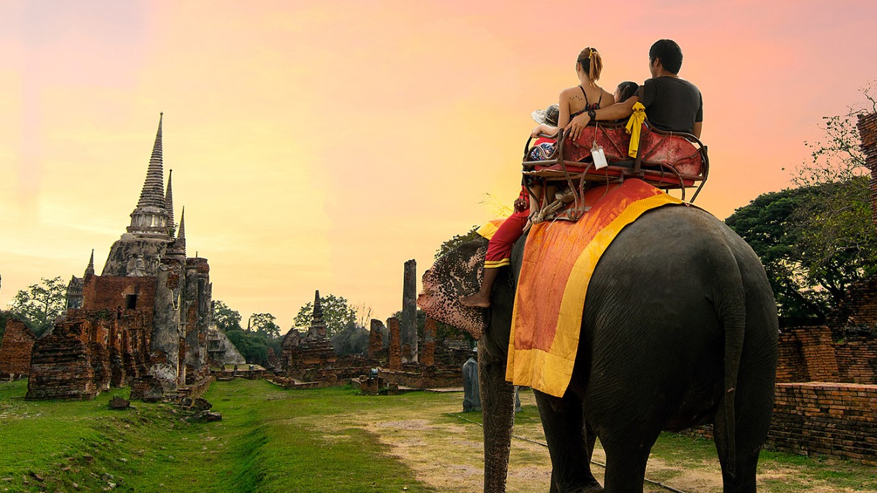 两个人在乘坐大象；图片使用于汇丰新加坡多币种账户
