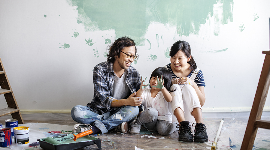 Asian family painting wall with hands.