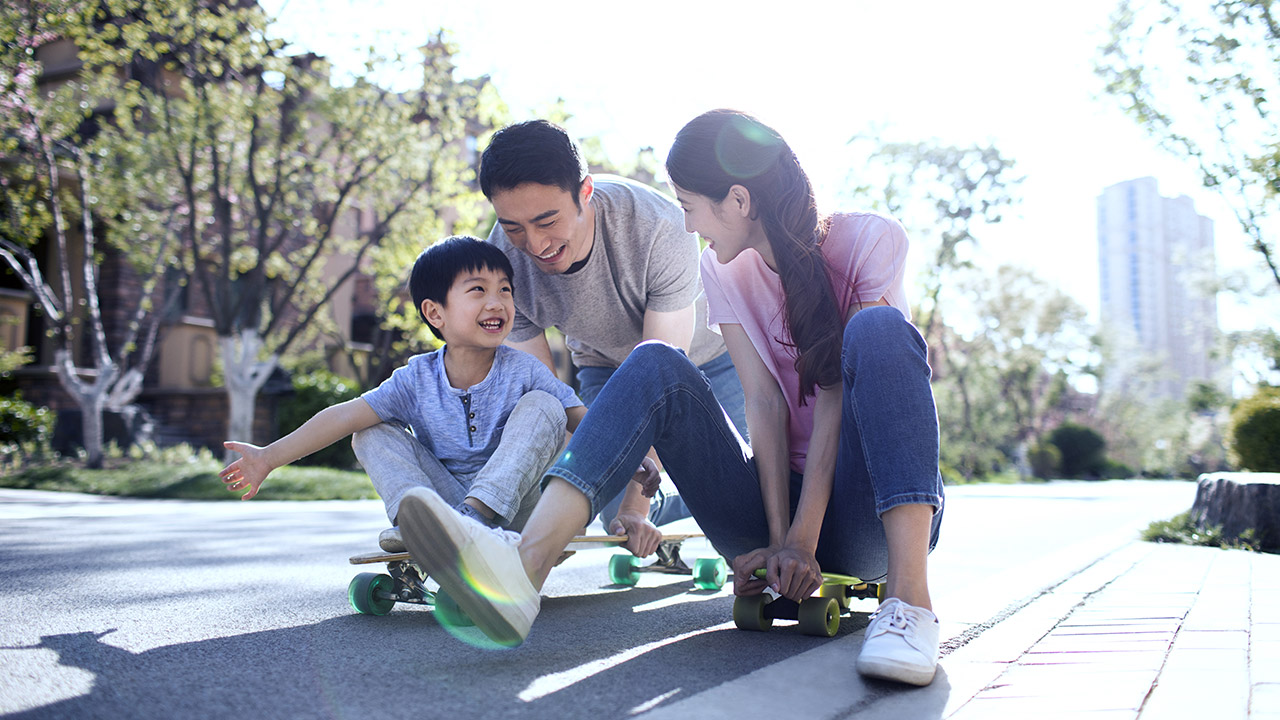 A family is playing skateboard on street.