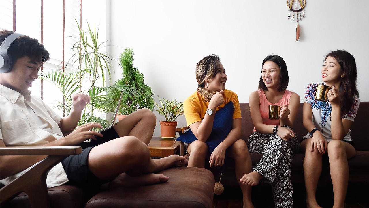 four friends laughing and chatting together; image used for HSBC Singapore expat Beginner's guide to Singlish article.