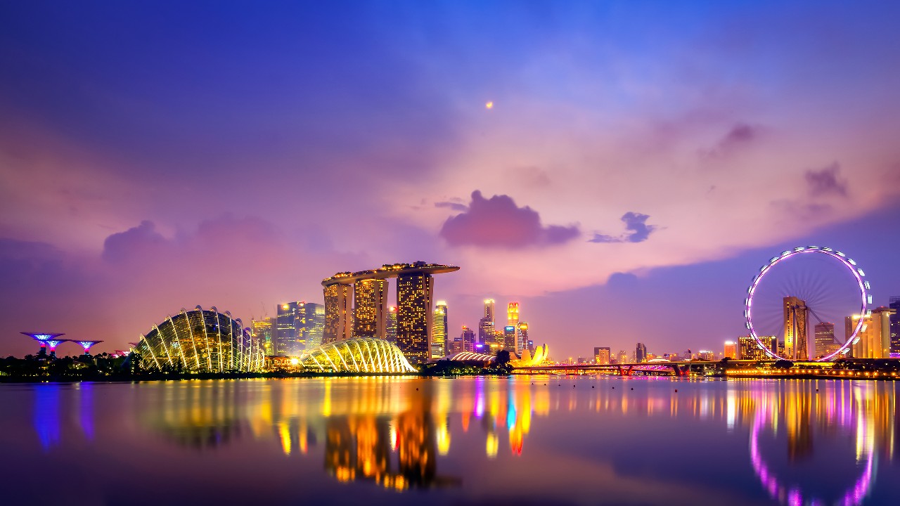 夕阳下的新加坡，灯光映在水面上；图片使用于汇丰新加坡外籍雇员指南。
