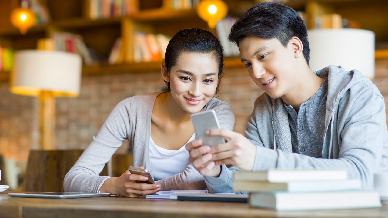 男女二人在看手机；图片使用于汇丰新加坡个人信用循环贷款推广。