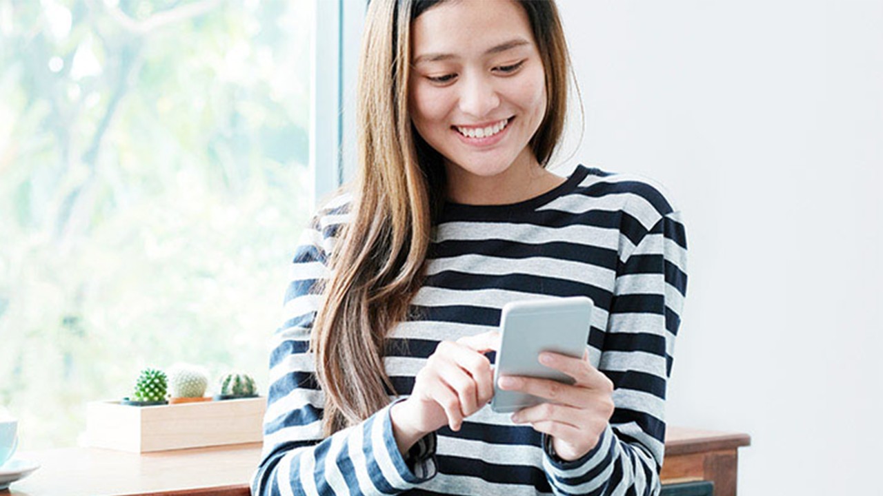 A woman is using her phone; image used for HSBC Singapore Promotions