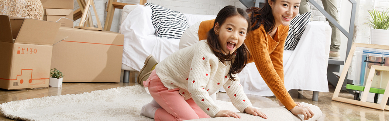 Woman and girl unrolling rug; image used for HSBC Singapore home rewards.