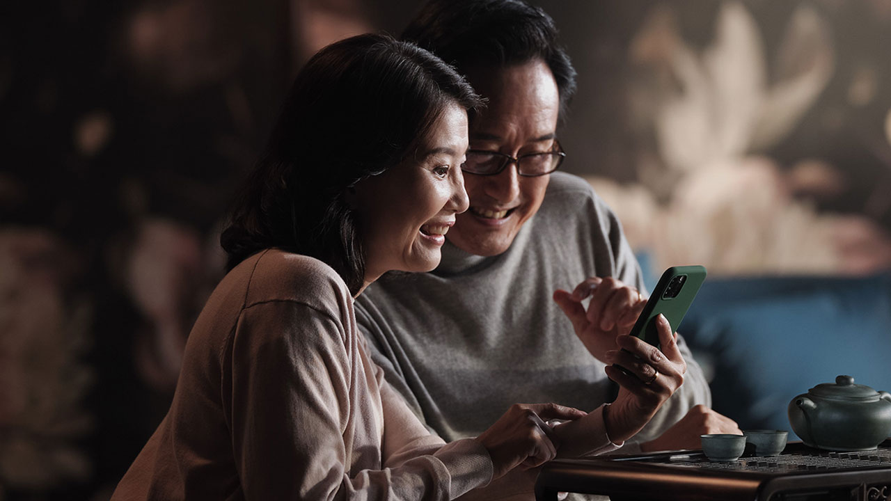 A couple looking at mobile phone; image used for HSBC Singapore Global Money Transfers. 