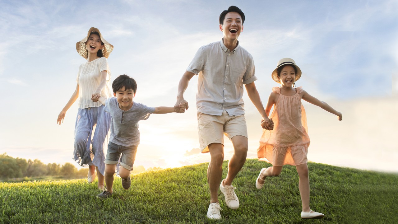Family running on meadow; image used on HSBC Singapore Personal Banking.