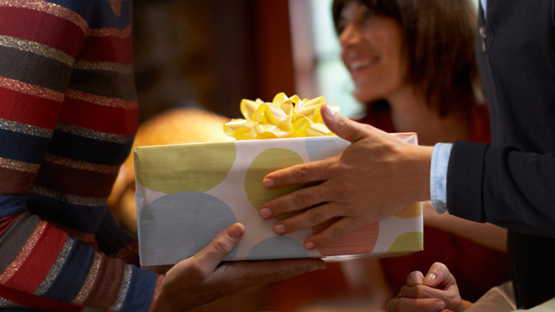 Two people are exchanging gifts; image used for HSBC Singapore Premier Mastercard