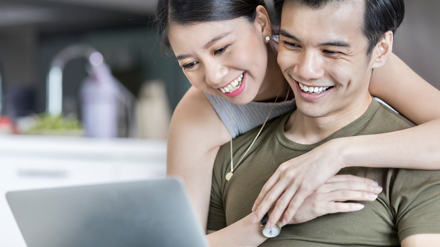 夫妇在看笔记本电脑；图片使用于汇丰新加坡“怎样的财务保障才算足够”一文页面。