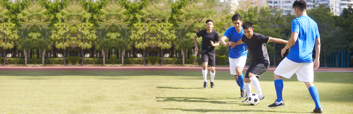 Young Asian adult men playing football; image used for HSBC Personal Accident Insurance - Smart PA Protect+.