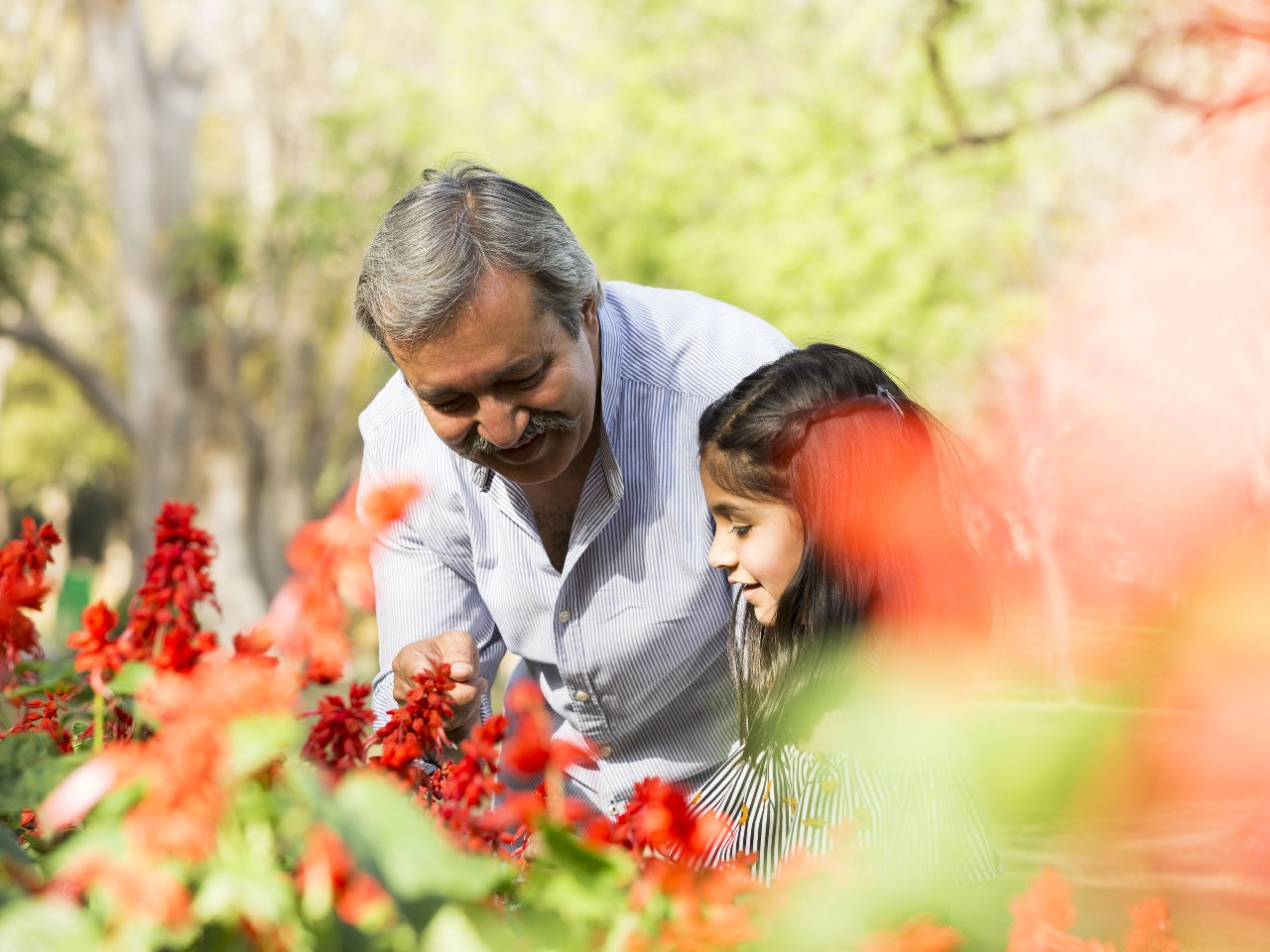 祖父和孙女在花园中游玩；图片使用于汇丰环球财富管理解决方案。